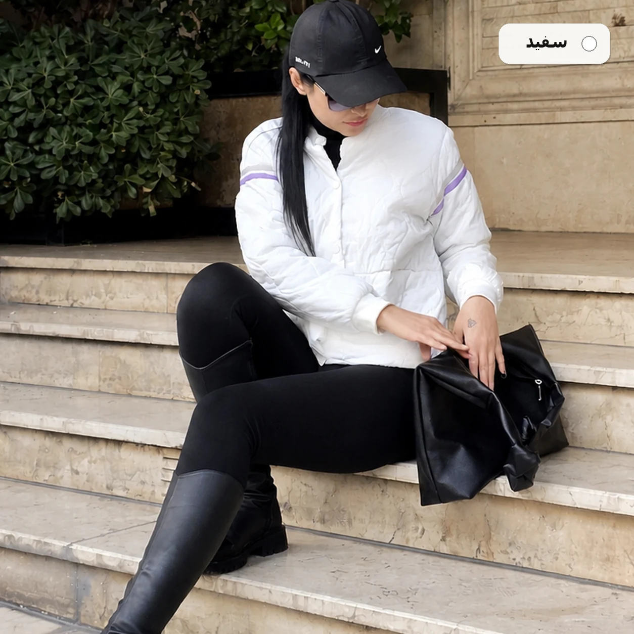 کاپشن زنانه سبک رنگ سفید، نمای اصلی مدل‌پوش نشسته